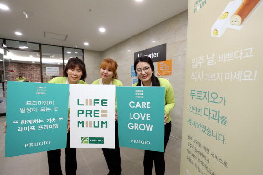 대우건설 관계자들이 지난달 30일 입주한 군산 디오션시티 푸르지오에서 라이프 프리미엄을 소개하는 팻말을 들고 있다.  대우건설 제공